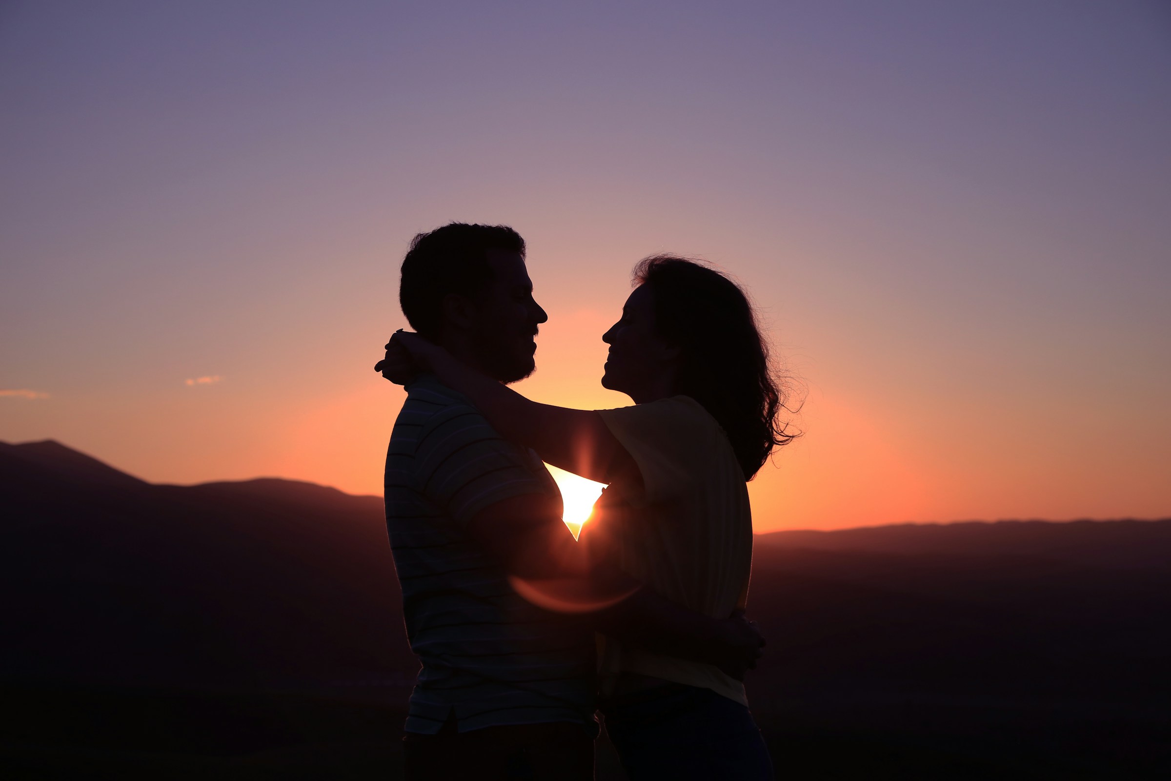A couple sharing a warm embrace at sunset
