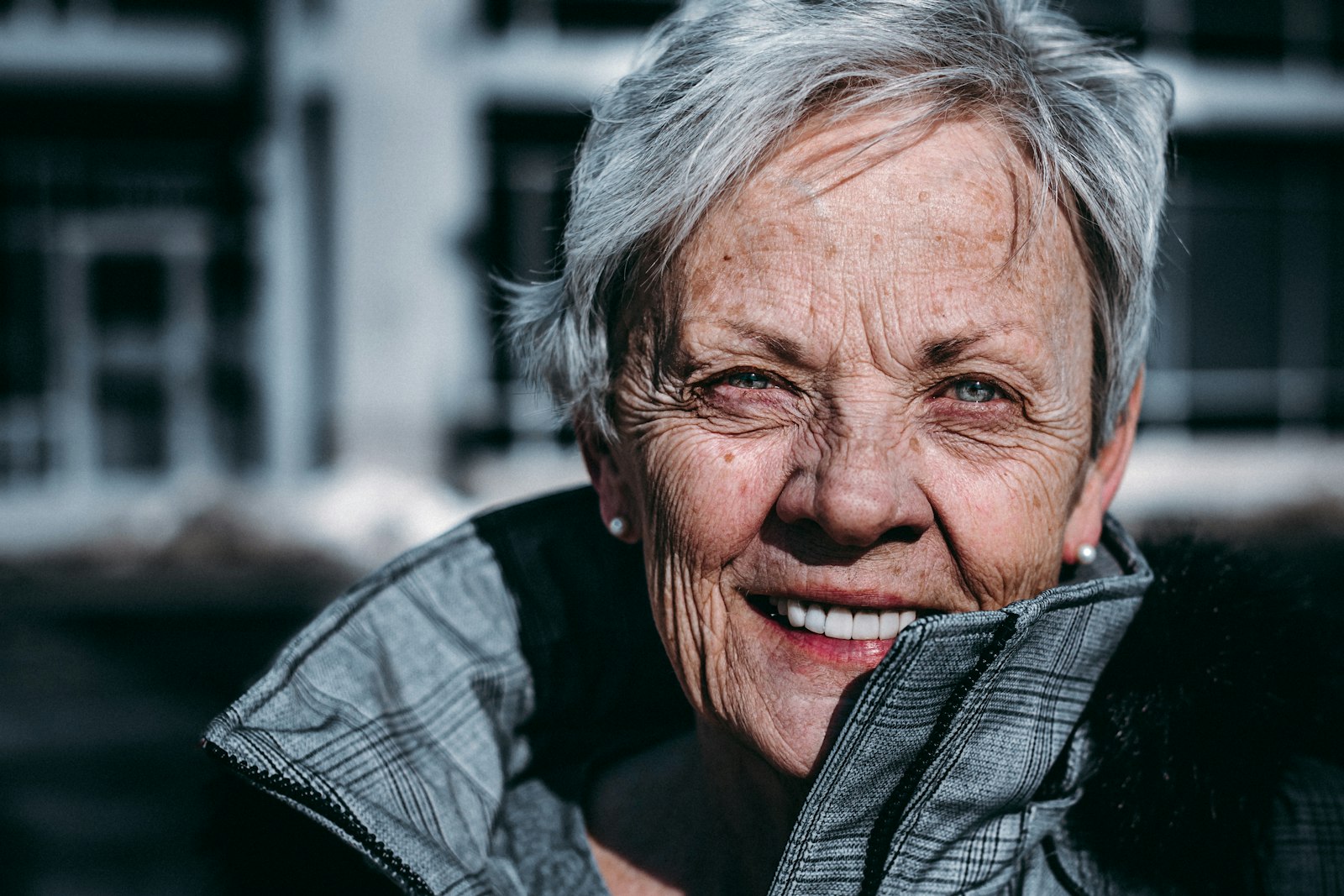 An older woman smiling warmly in sunlight