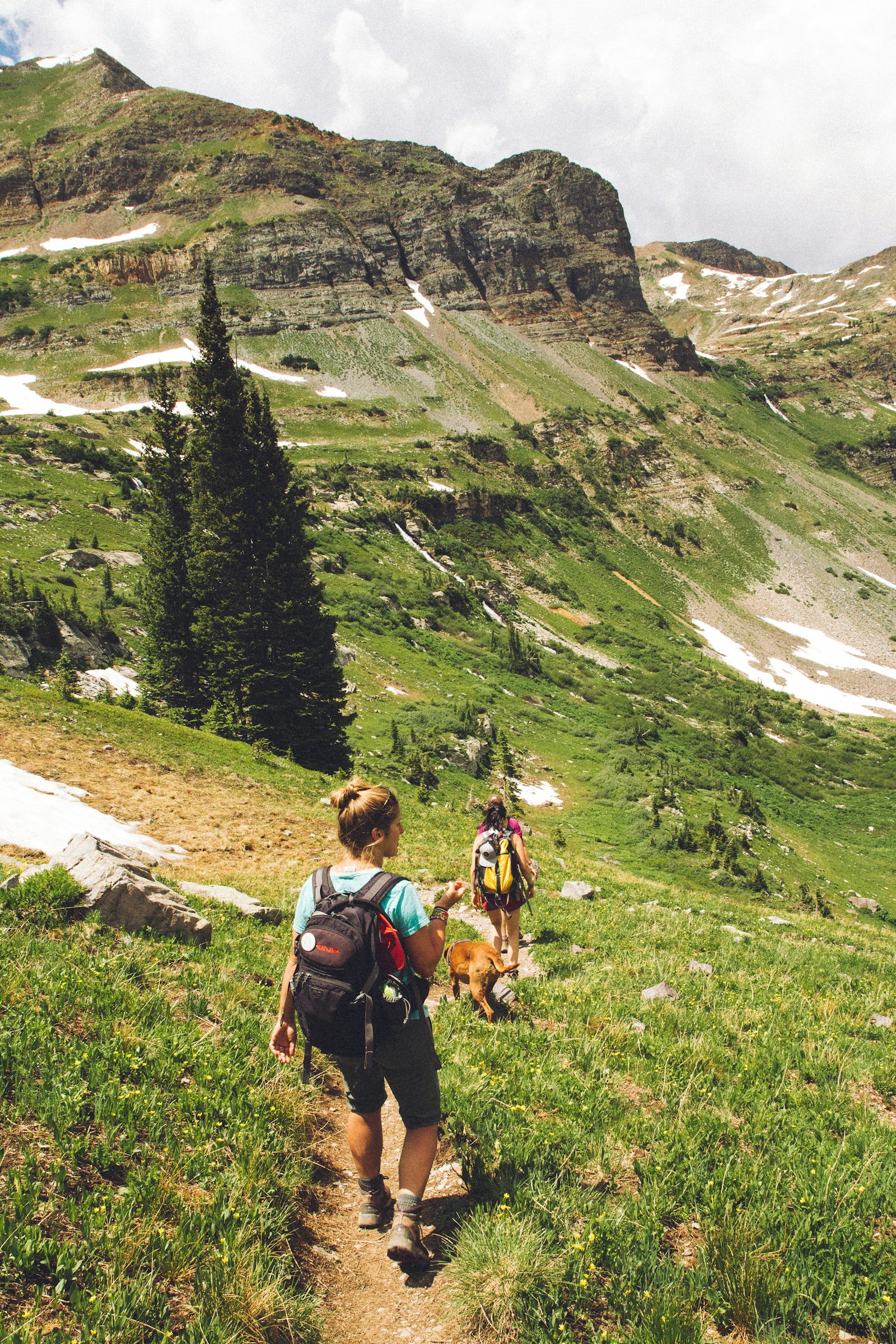 Two people walking together on a sunny trail